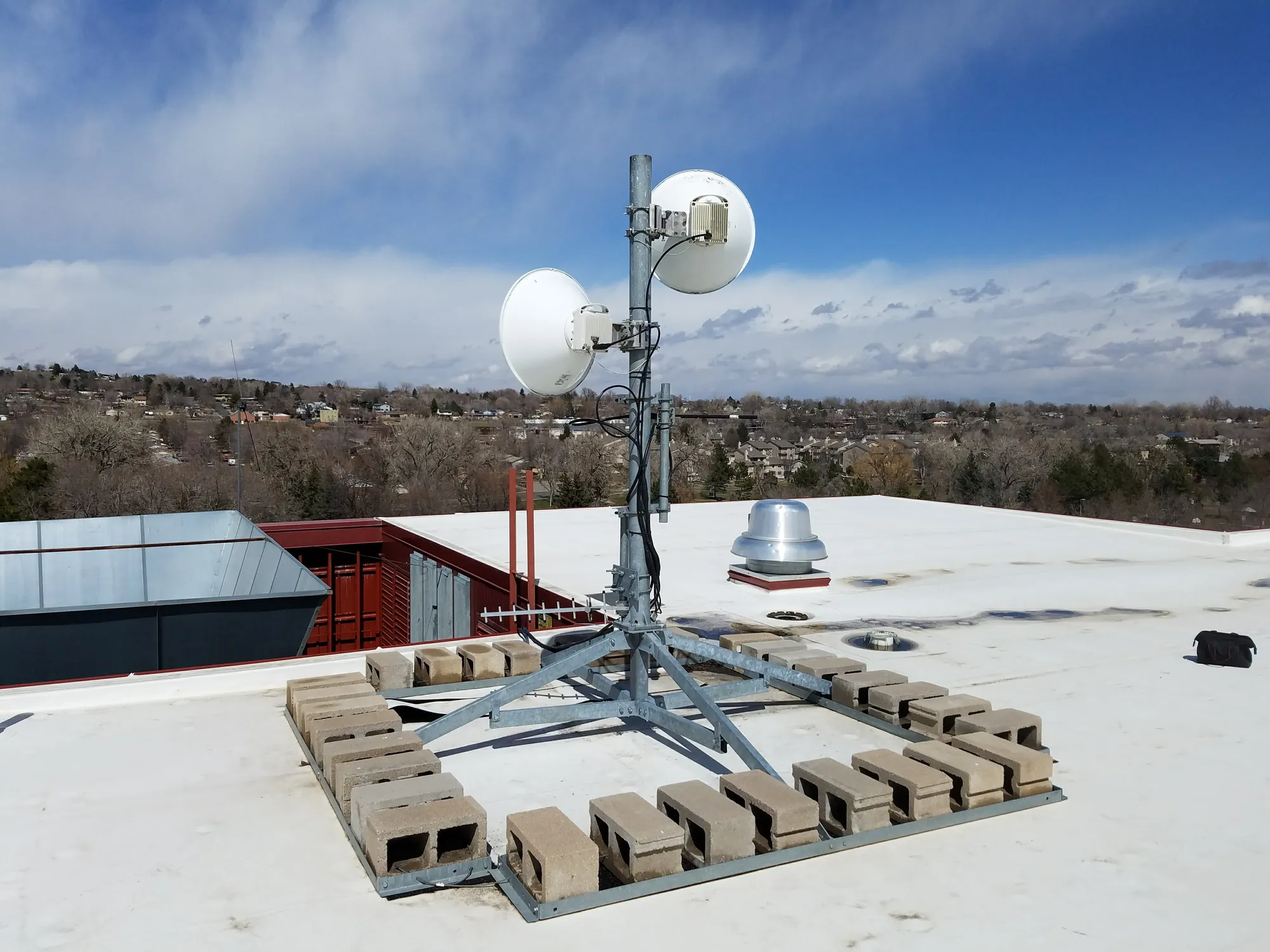 Rooftop point-to-point microwave backhaul link with paired dish antennas, a wireless network deployment managed 24/7 by Twin Eagle Solutions